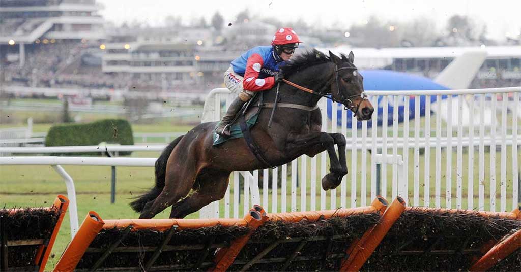 A horse and its jockey clearing a hurdle in a national hunt horse race.